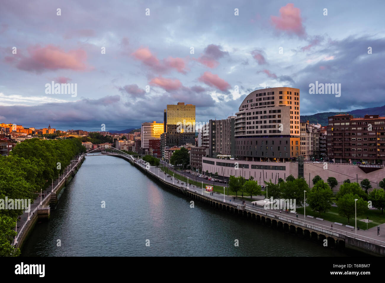 Bilbao riverside nelle vicinanze del Museo Guggenheim durante il tramonto, vista da La Salve bridge. Ponte Calatrava Foto Stock