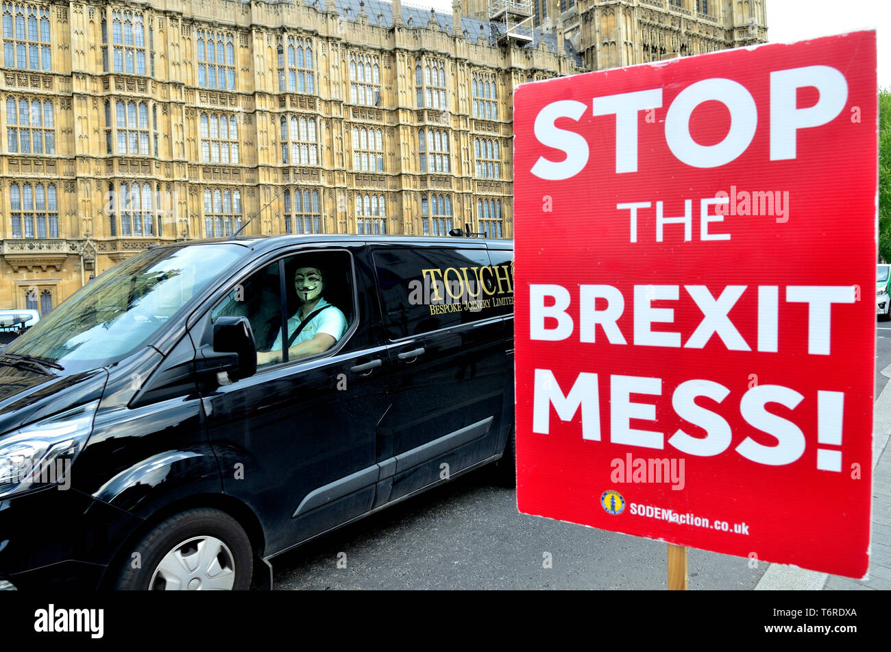 Londra, Inghilterra, Regno Unito. Uomo che indossa un V per Vendetta maschera nel sedile del passeggero di un furgone, passando per le Case del Parlamento Foto Stock