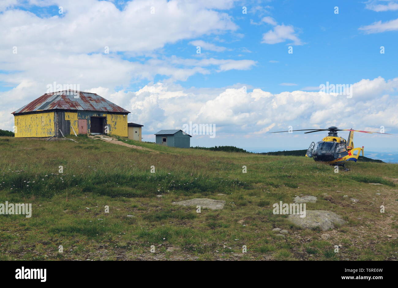 Elicottero giallo e hut su un prato Foto Stock