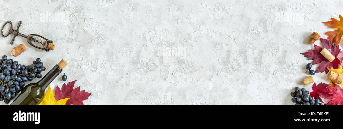 Bottiglia, uve nere e colorate Foglie di autunno. Foto Stock