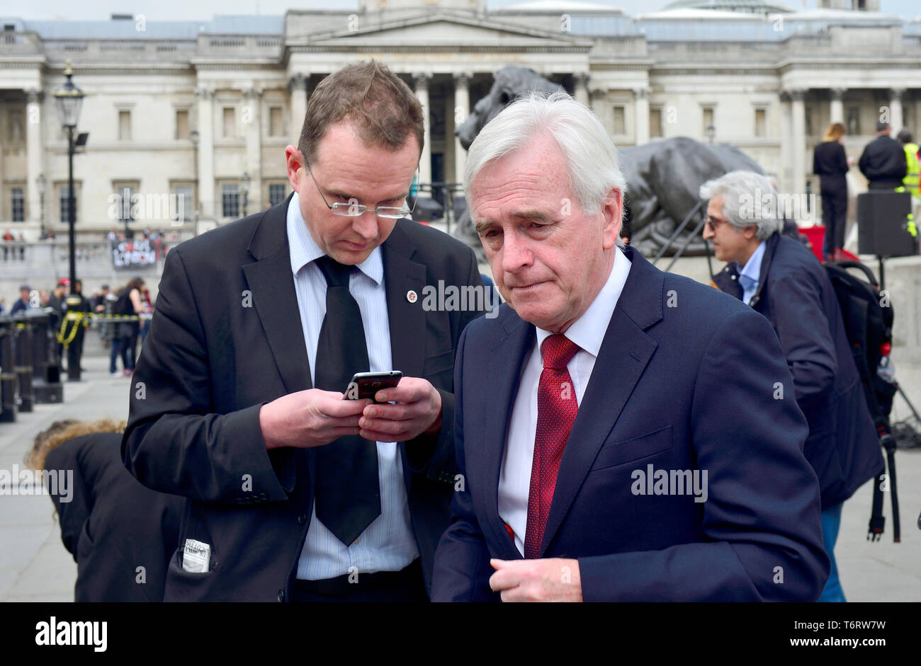 John McDonnell MP (Manodopera: Hayes e Harlington) cancelliere ombra, con la sua testa di comunicazioni strategiche - Andrew Whitaker, in Trafalgar Square Foto Stock