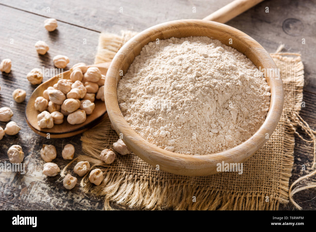La farina di ceci in ciotola di legno su un tavolo di legno Foto Stock