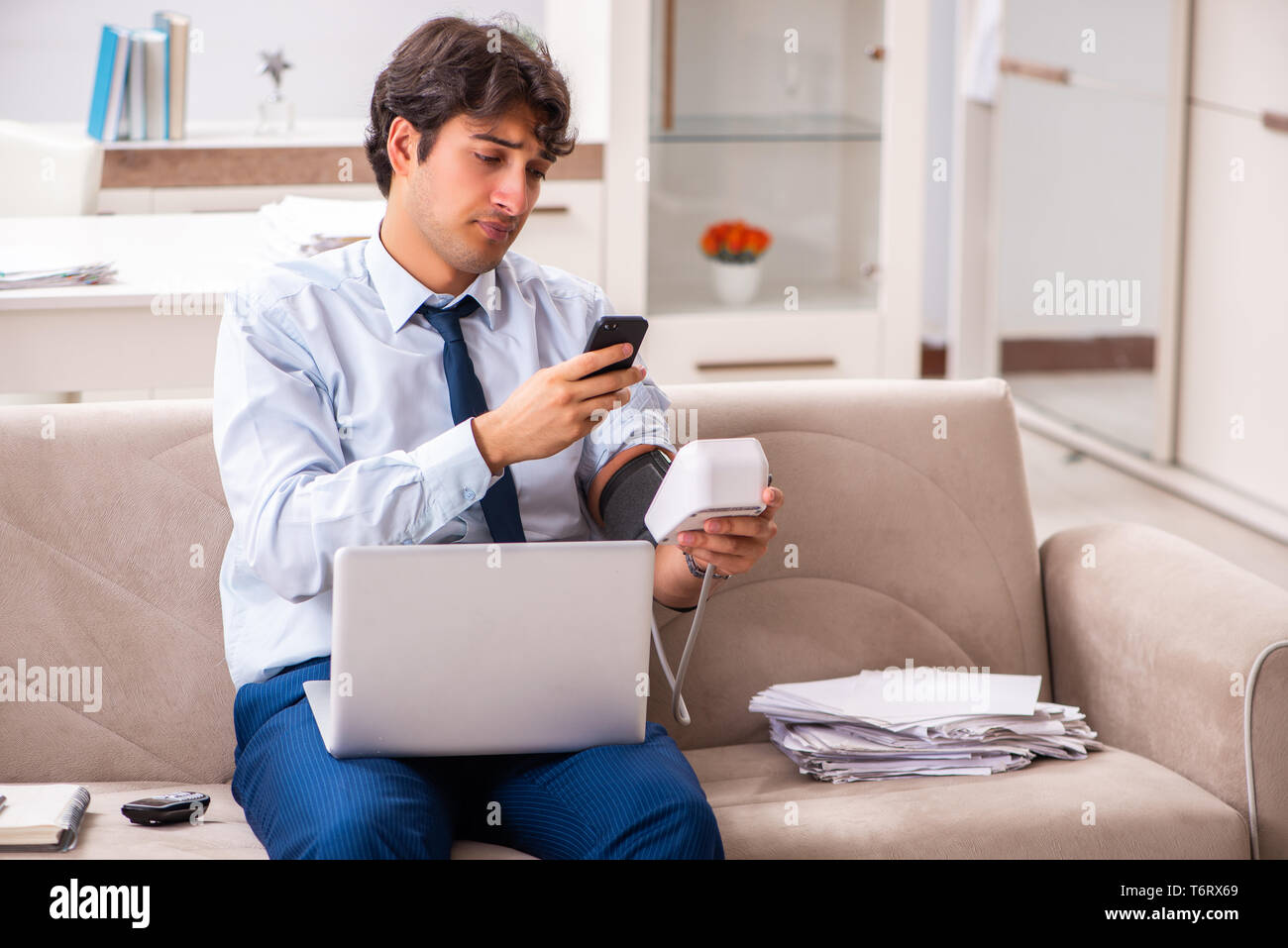 L'uomo sotto stress misurando la sua pressione del sangue Foto Stock