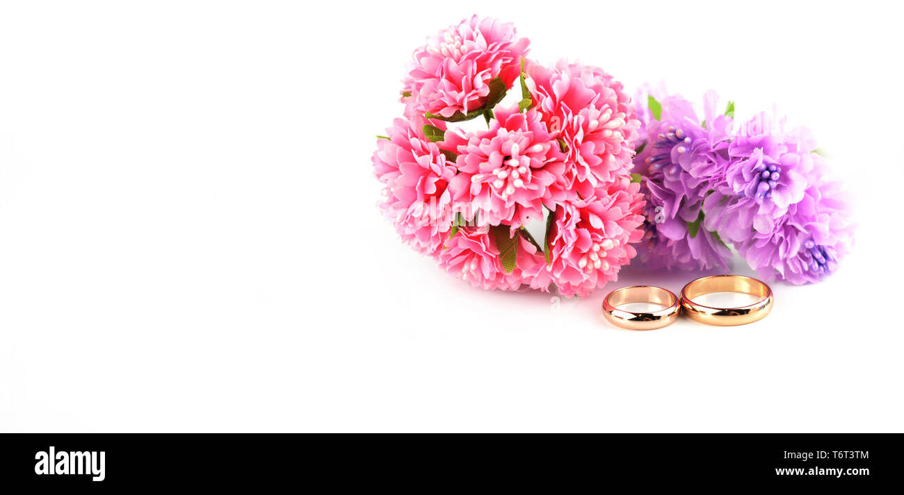 Nozze d'oro gli anelli di fidanzamento con pizzo lilla fiori su sfondo bianco Foto Stock