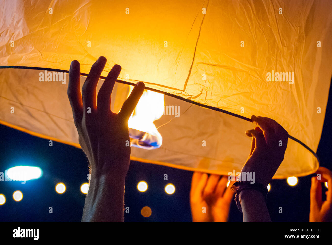 Il rilascio di una luce di lanterna durante il Loy Krathong festival in Chiang Mai, chiudere l immagine di mani Foto Stock