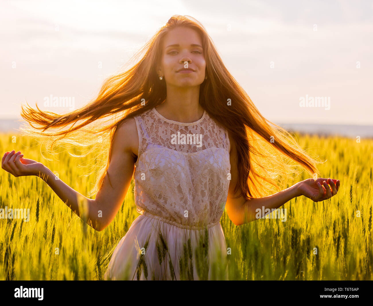 Ragazza con capelli fluenti retroilluminati da tramonto Foto Stock