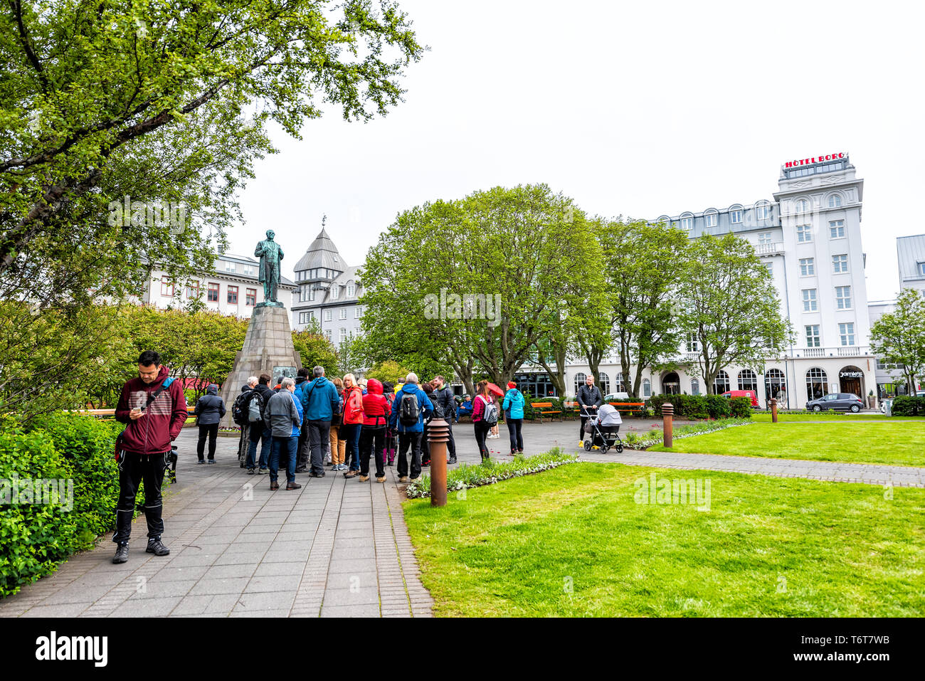 Reykjavik, Islanda - 19 Giugno 2018: il centro città capitale street con Sigurdsson Statua in Austurvollur Park e tour gruppo persone Foto Stock