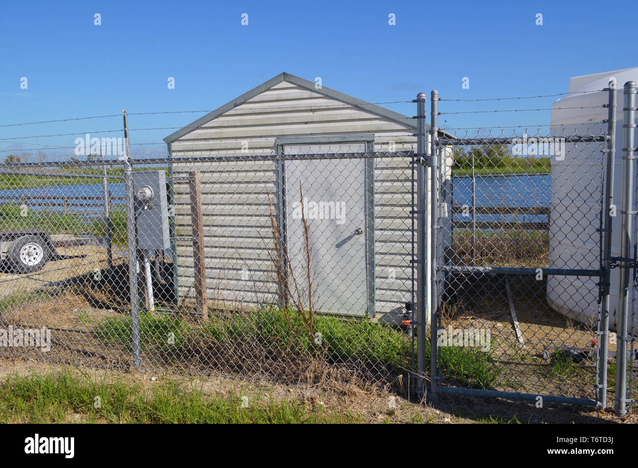 All'aperto giorno tempo vista ravvicinata di piccolo bloccato in metallo capannone di storage esterno Filo spinato racchiuso protetta sicuro Business industriale recintato nella zona Foto Stock