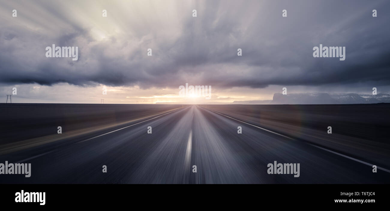 Strada che conduce verso il tramonto con motion blur effetto Foto Stock