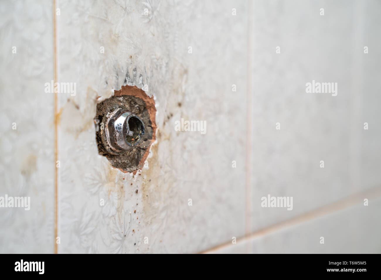 Tubo rotto in corrispondenza della parete di piastrelle in bagno Foto stock  - Alamy