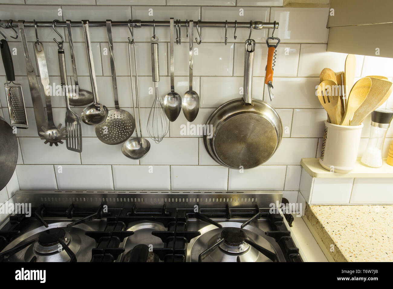 Articoli da cucina appesi in una accogliente cucina vintage al di sopra del forno Foto Stock