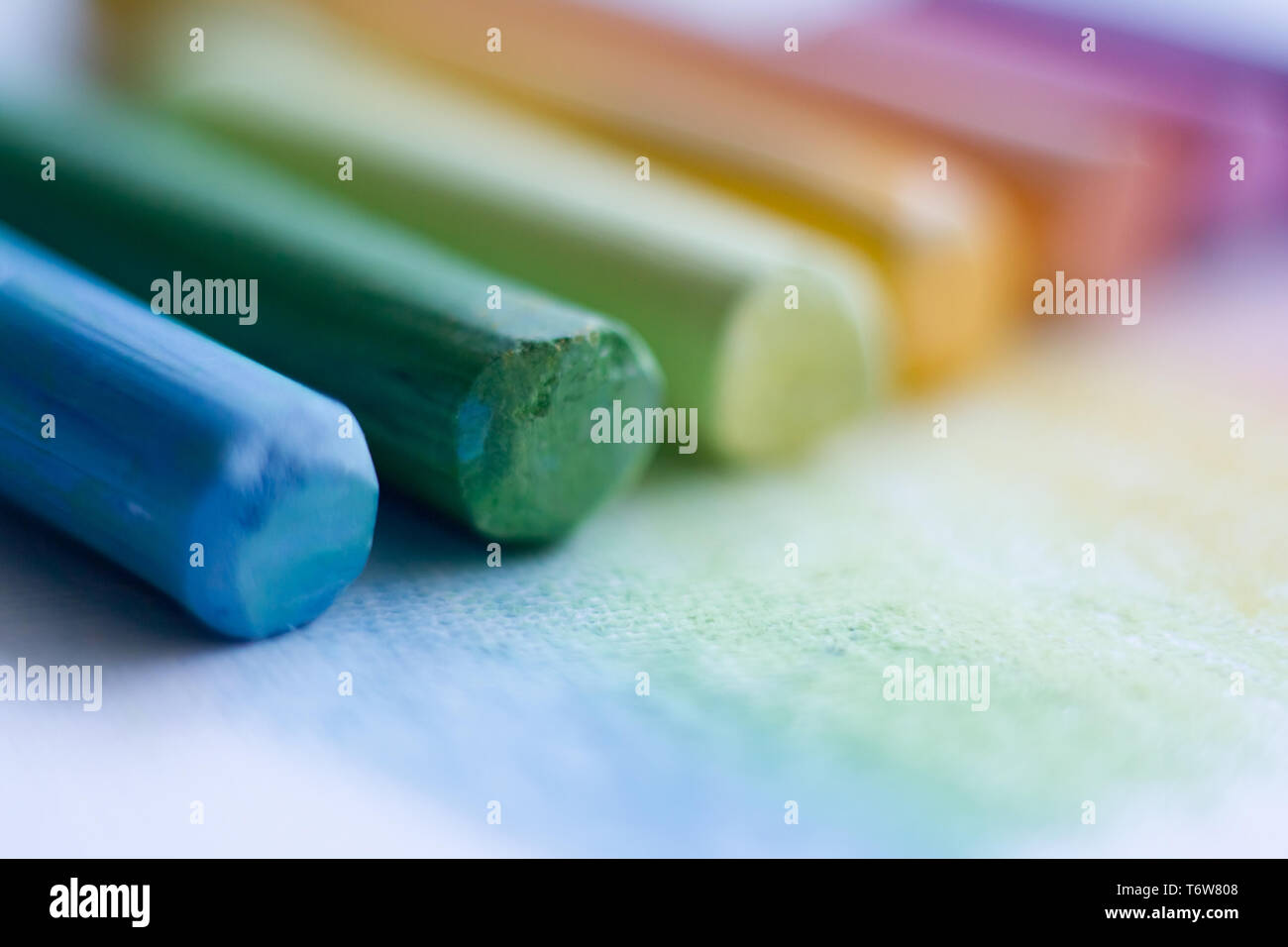 Extreme close-up di variopinti gessi pastello su una superficie bianca, il fuoco selettivo Foto Stock
