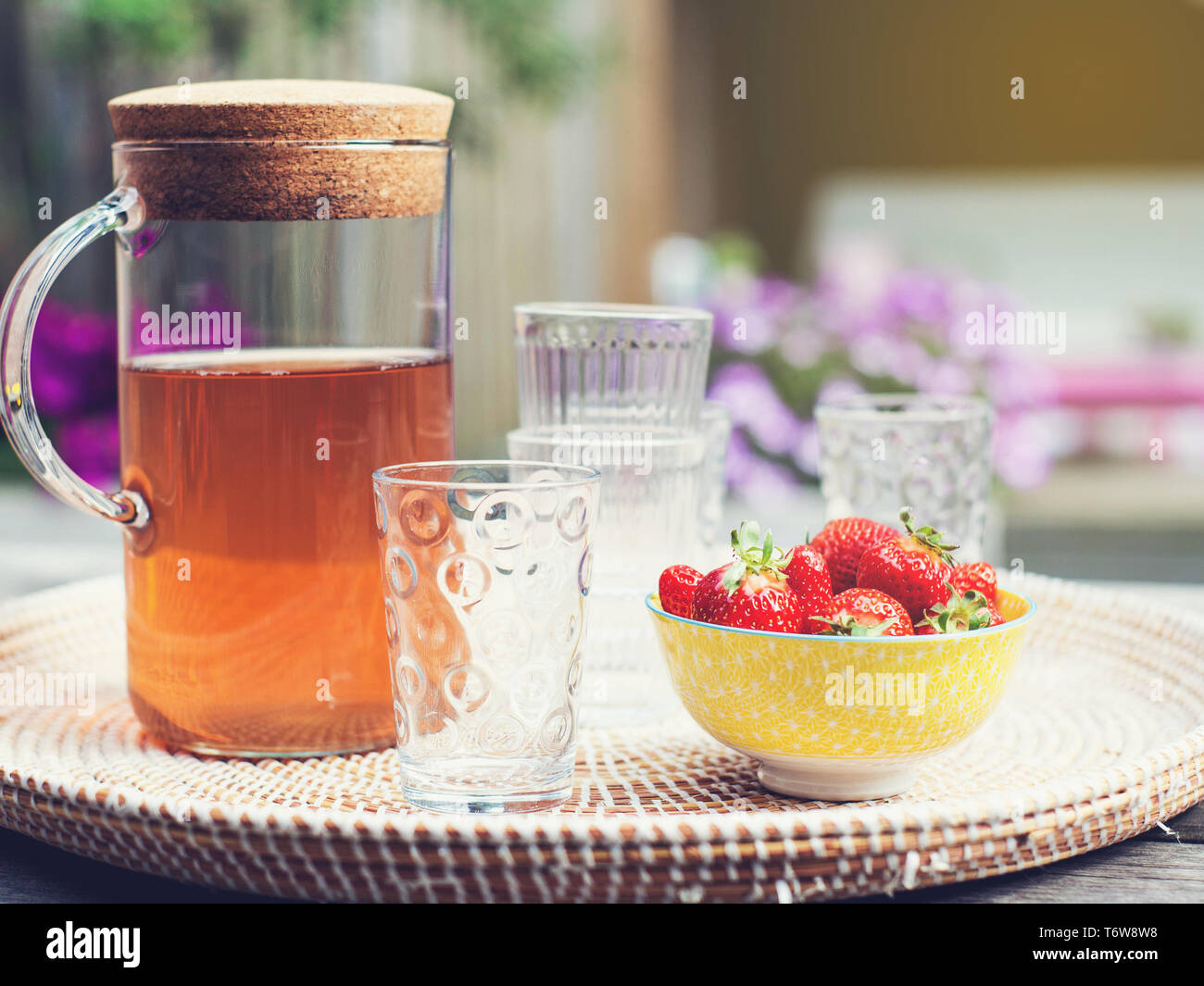 Fresca limonata fatta in casa con fragole all'aperto sul tavolo da giardino in estate Foto Stock