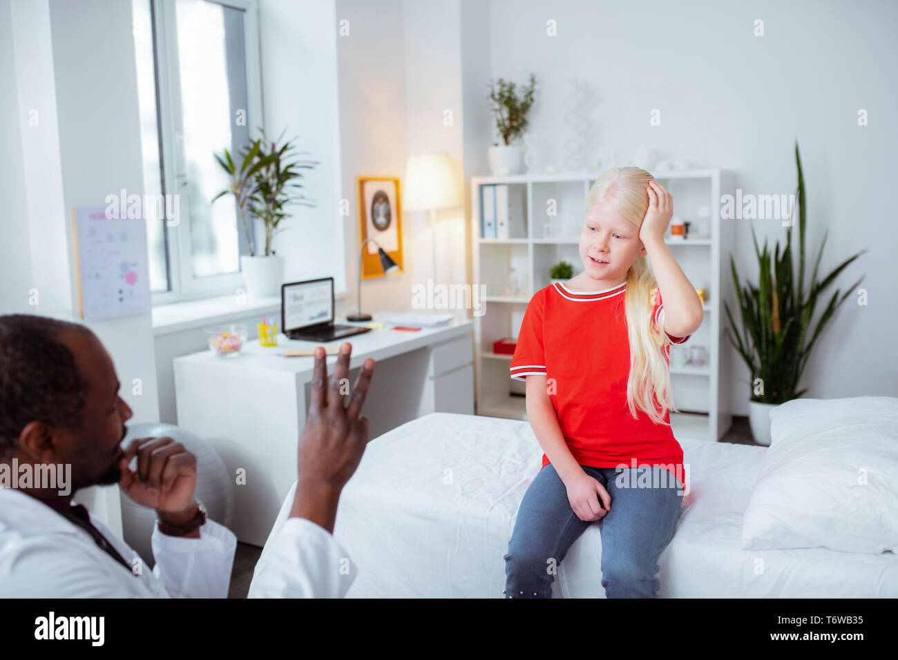 Ragazza con commozione cerebrale dopo la caduta di rispondere alle domande del medico Foto Stock