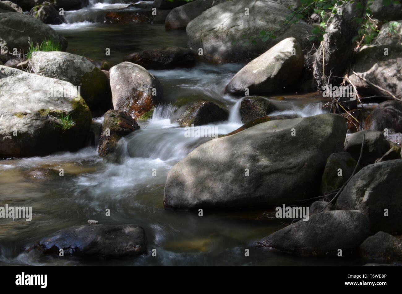 Rio con grande flusso di acqua formando cascatelle tra i sassi, prendendo la foto con effetto seta Foto Stock