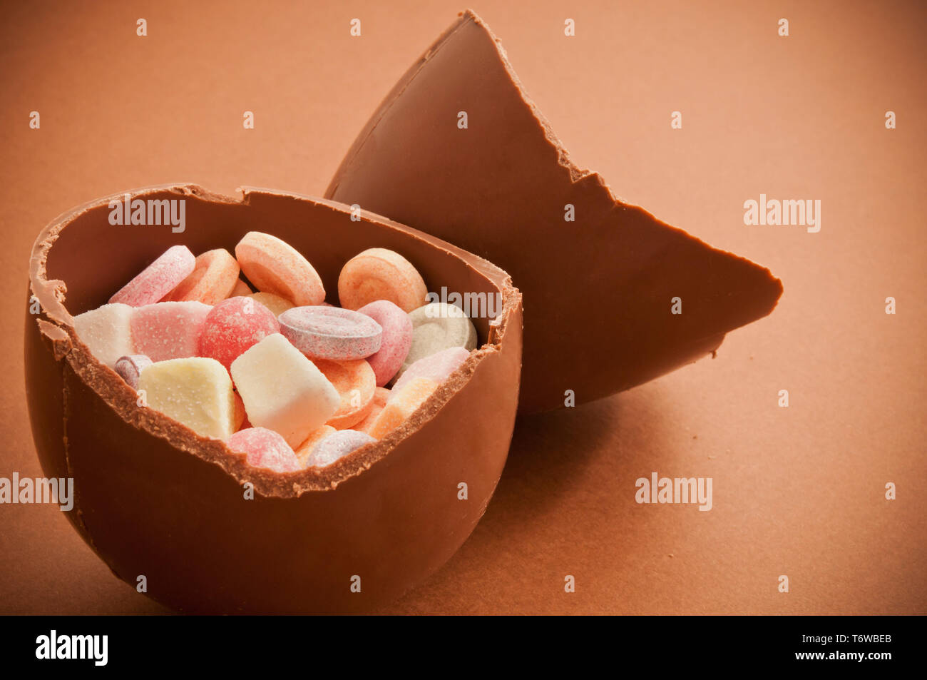 Pasqua tradizionale uovo di cioccolato rotto in metà e riempito con caramelle Foto Stock