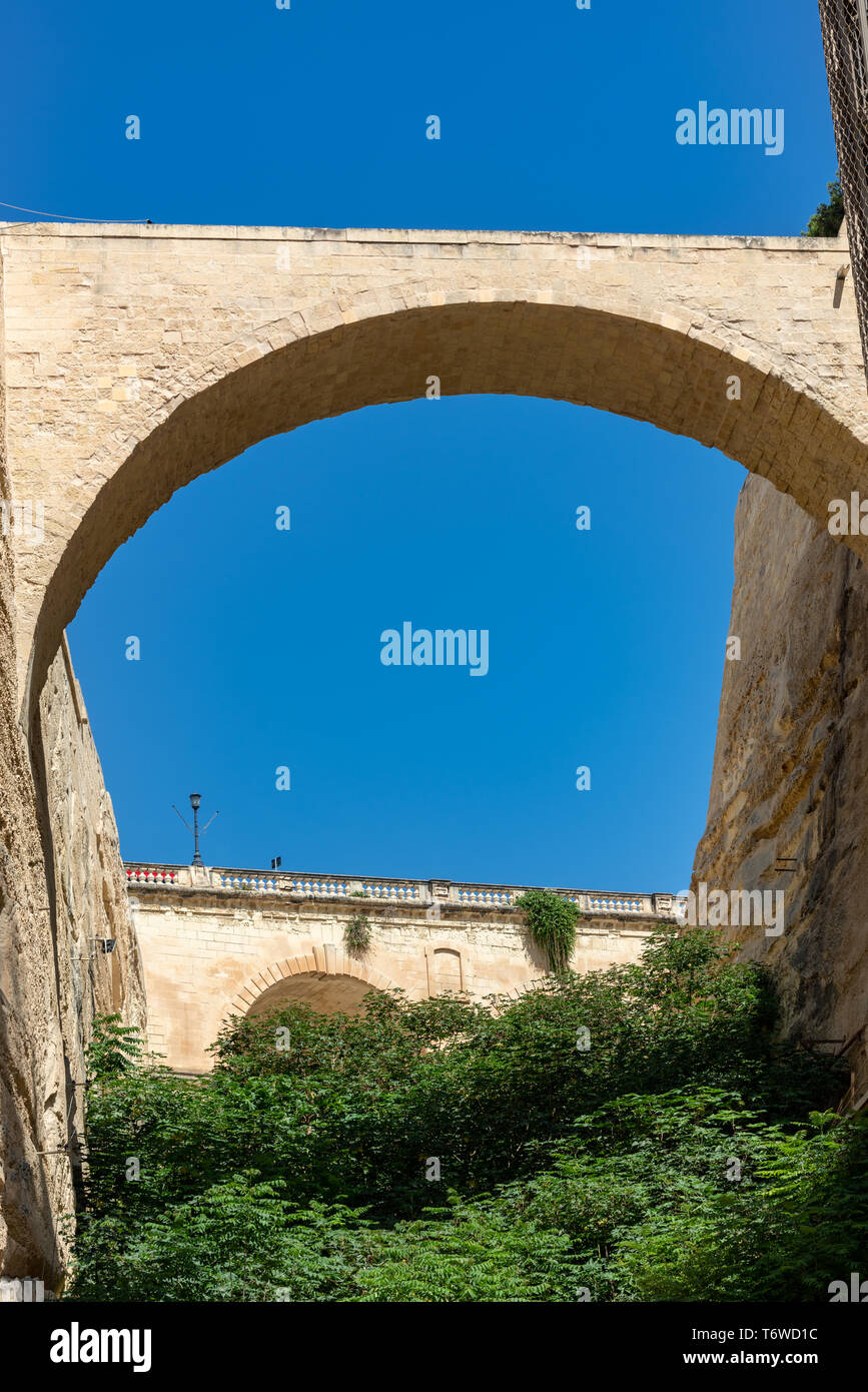 Un alto ponte ad arco collega il Bastione di San Pietro e Paolo con la Controguardia di San Pietro e Paolo nelle storiche fortificazioni calcaree della Valletta Foto Stock