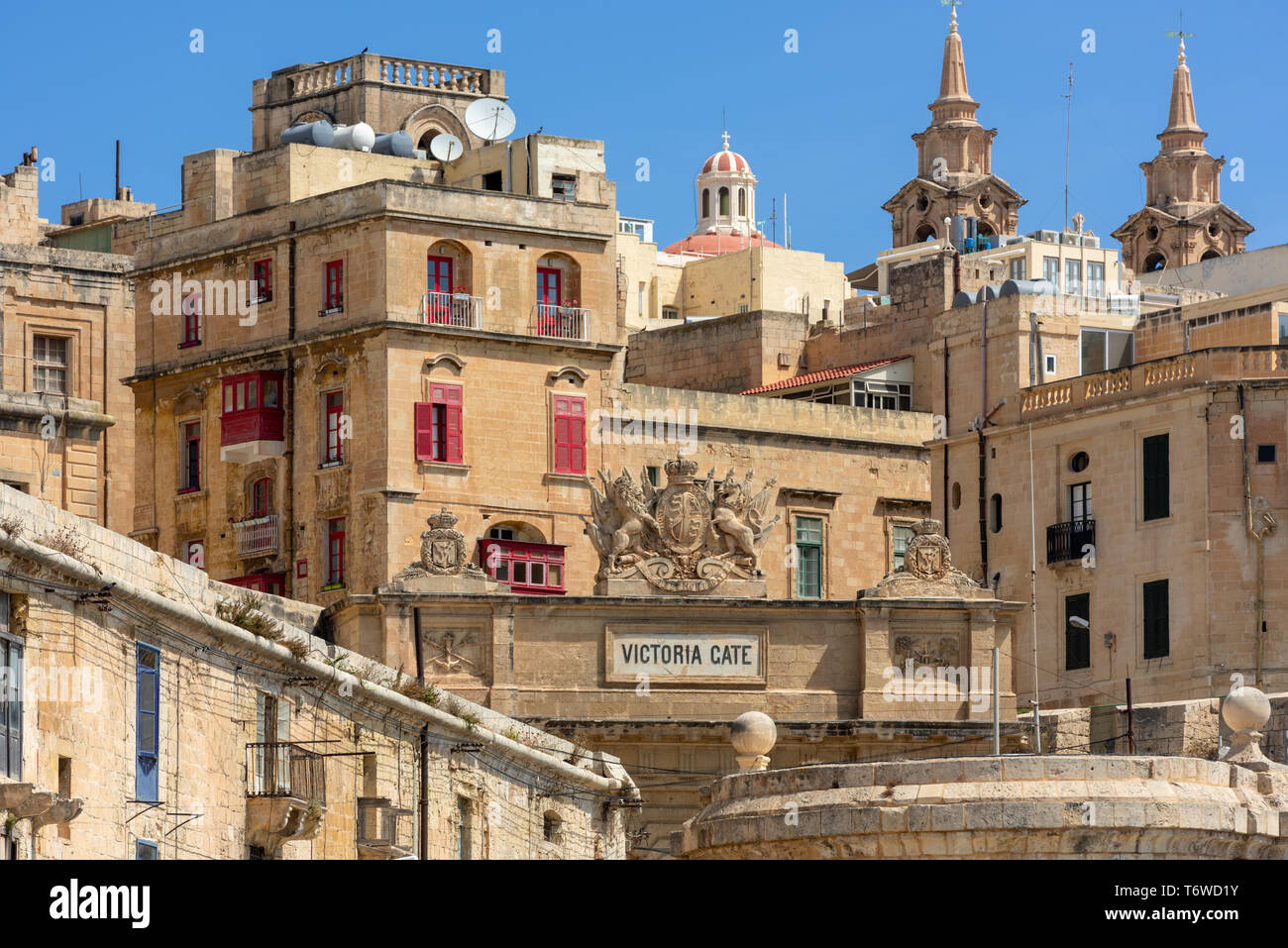 La storica porta Vittoria calcarea di Valletta e la lanterna e le torri gemelle della Chiesa del relitto di San Paolo Foto Stock