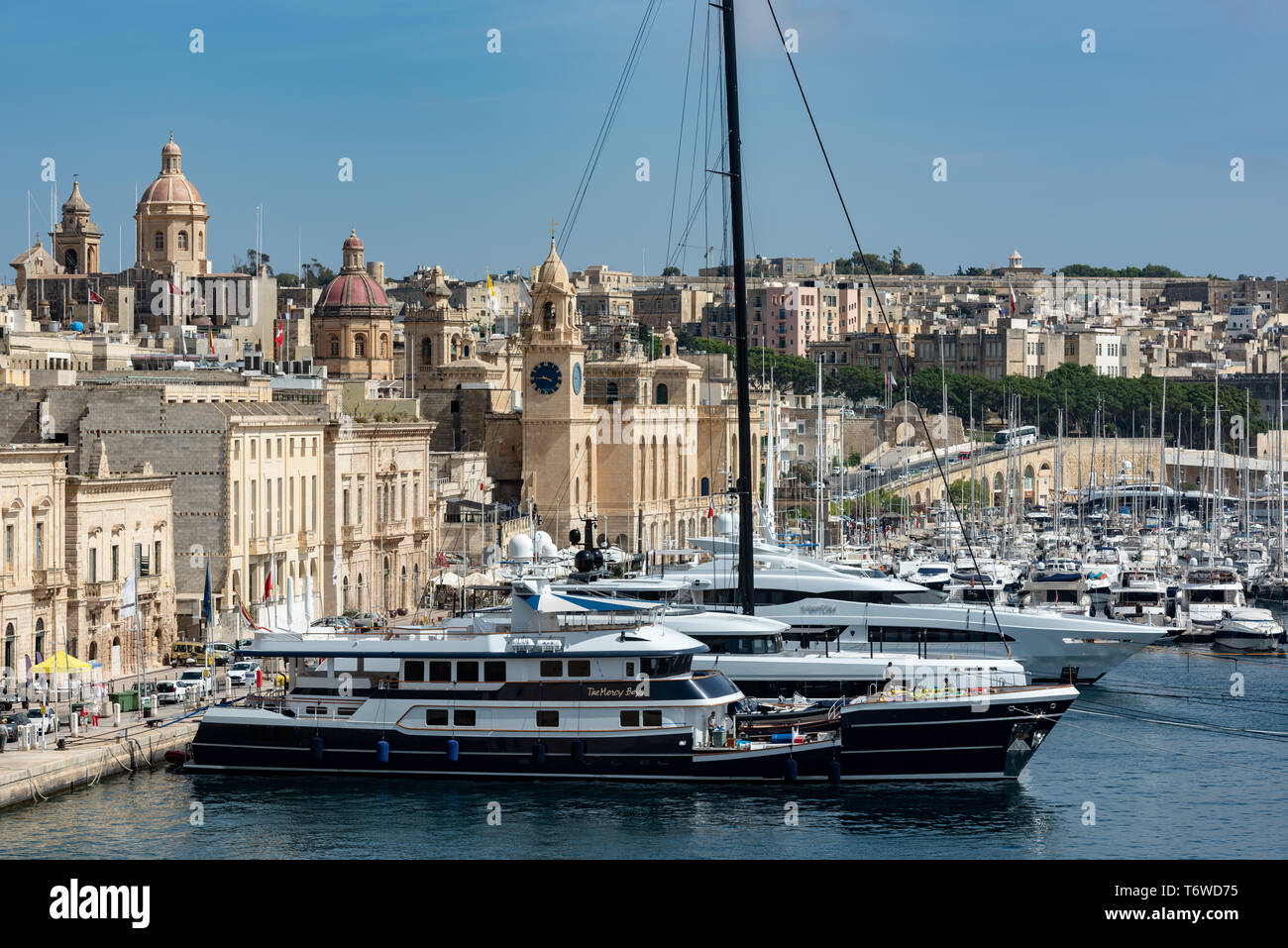 Gli yacht di lusso e le imbarcazioni da diporto ormeggiate nel Dockyard Creek del Grand Harbour di la Valletta si affacciano sugli storici edifici calcarei di il-Birgu. Foto Stock