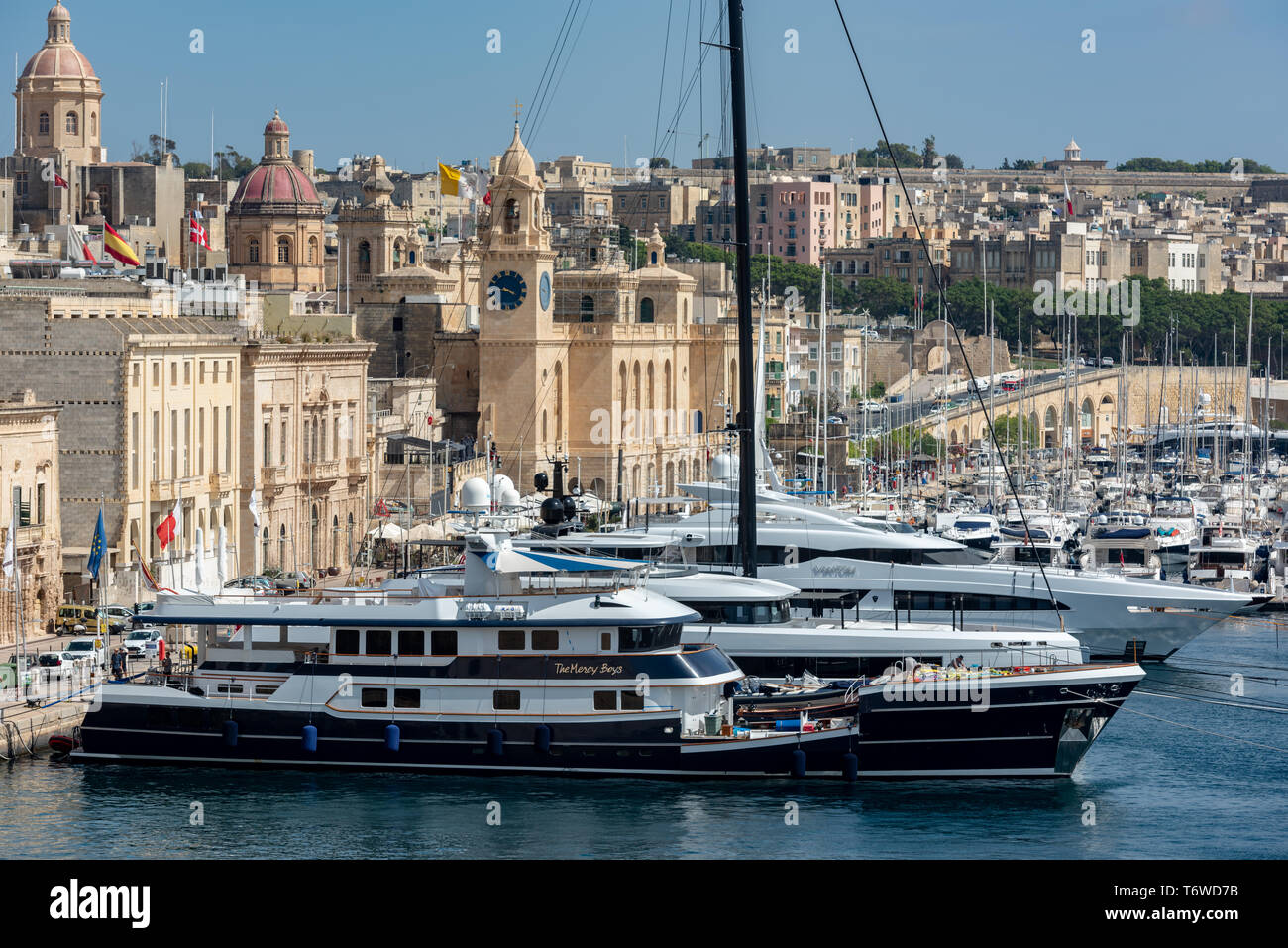 Gli yacht di lusso e le imbarcazioni da diporto ormeggiate nel Dockyard Creek del Grand Harbour di la Valletta si affacciano sugli storici edifici calcarei di Birgu. Foto Stock