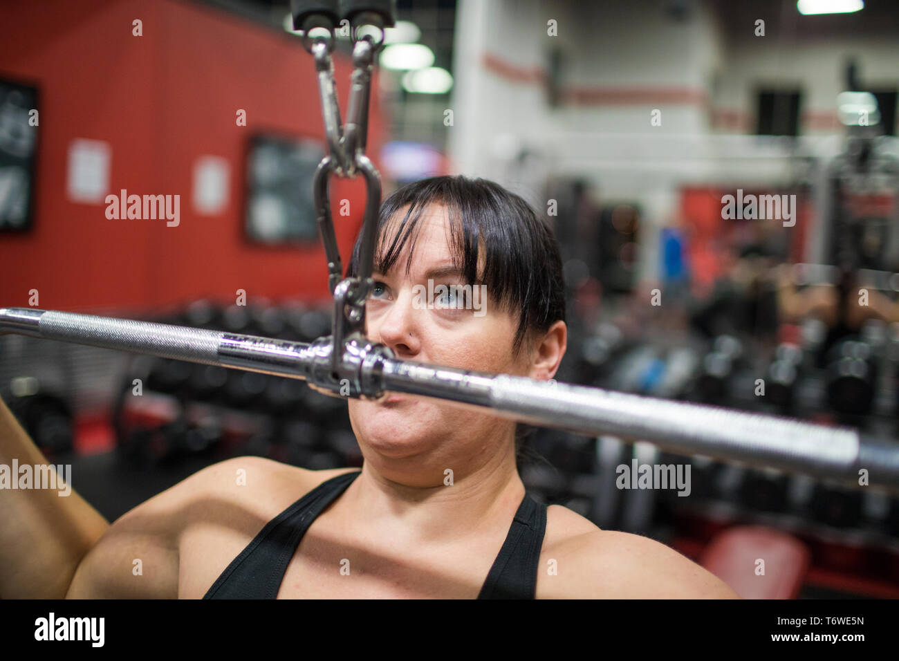 Donna forte che esercitano sulla macchina in palestra Foto Stock