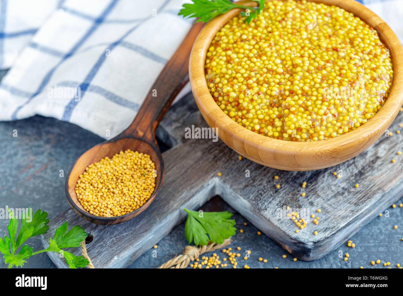 Piccante di seme di senape in una ciotola di legno. Foto Stock