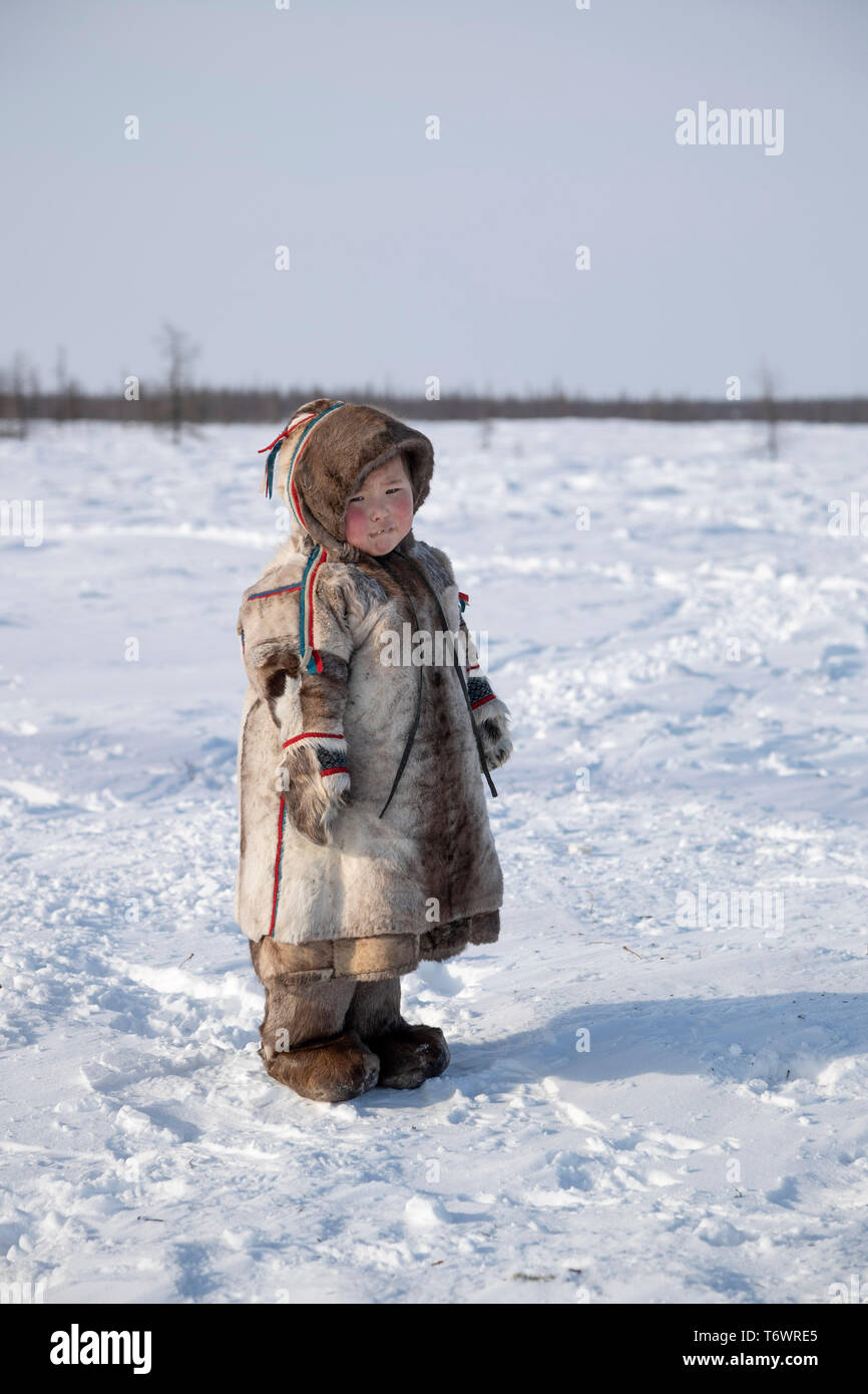 Russia, Yamal-Nenets Regione autonoma, penisola di Yamal. Nenets nomadi allevatori di renne camp, un giovane bambino in abito tradizionale. Foto Stock
