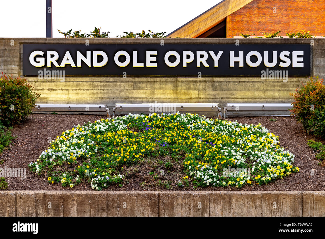 Un segno al Grand Ole Opry circondato da aiuole di fiori con sede dietro di esso. Foto Stock