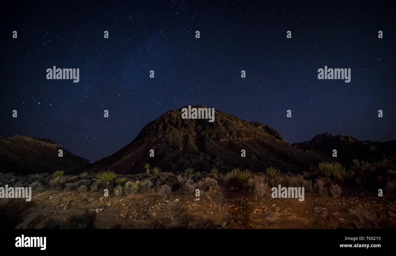 La notte e il cielo scuro oltre il parco nazionale della Valle della Morte Foto Stock