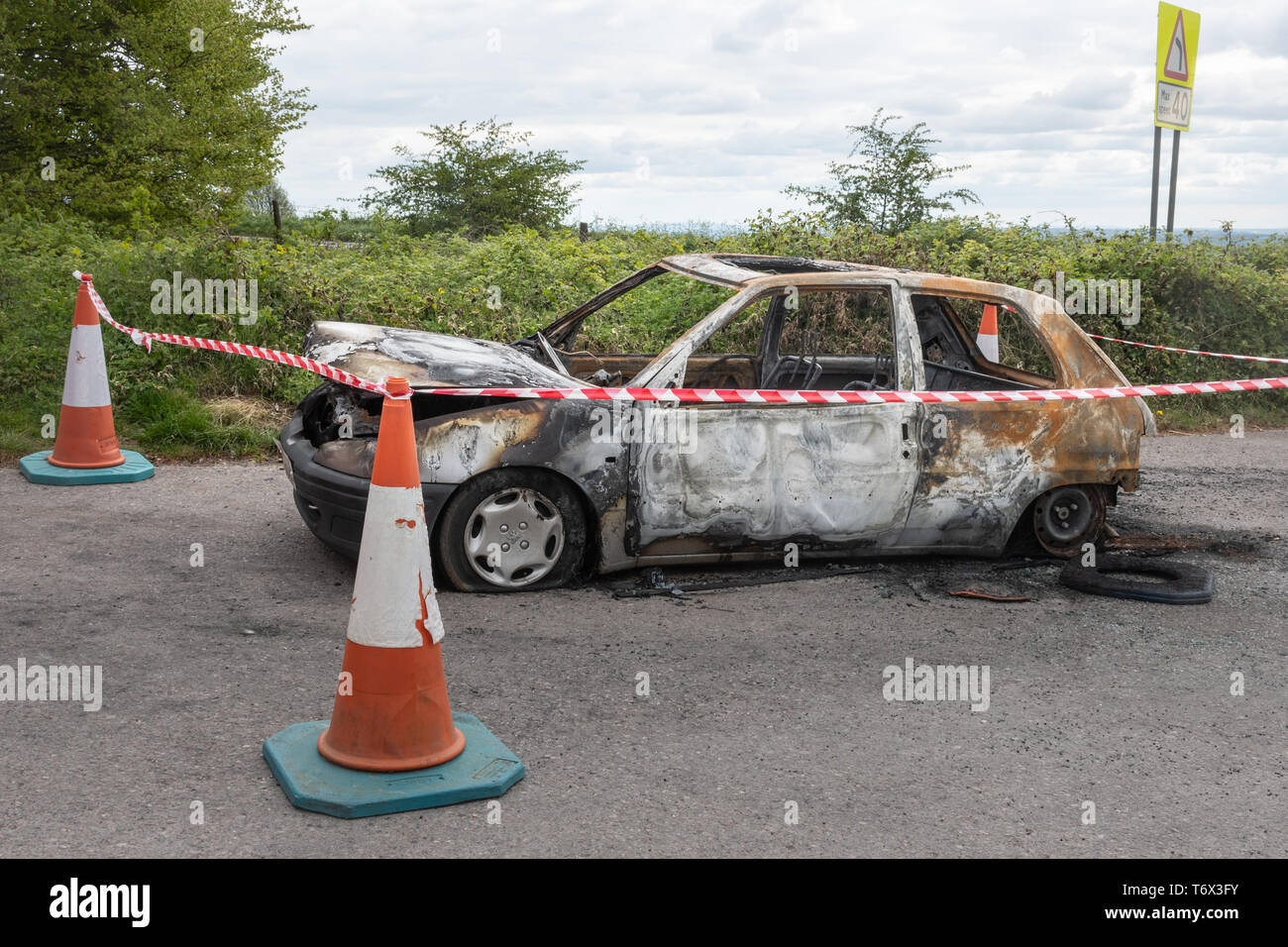 Bruciata auto abbandonate in un paesaggio car park, Regno Unito Foto Stock