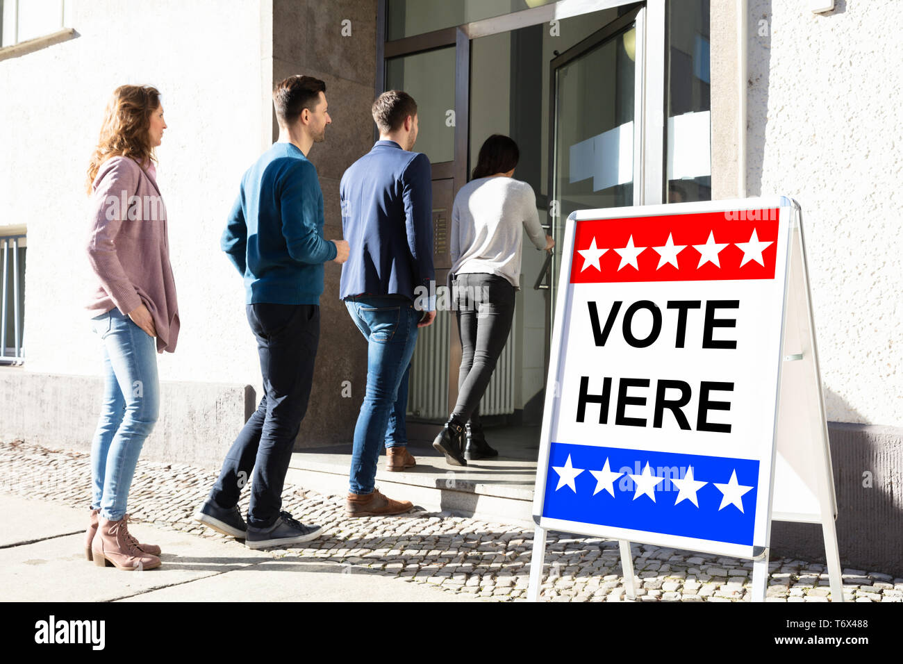 Un gruppo di giovani in piedi all'ingresso della camera di voto Foto Stock