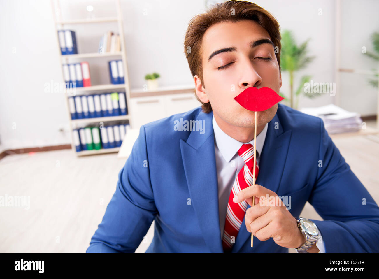 Funny bisinessman con finti labbra in ufficio Foto Stock