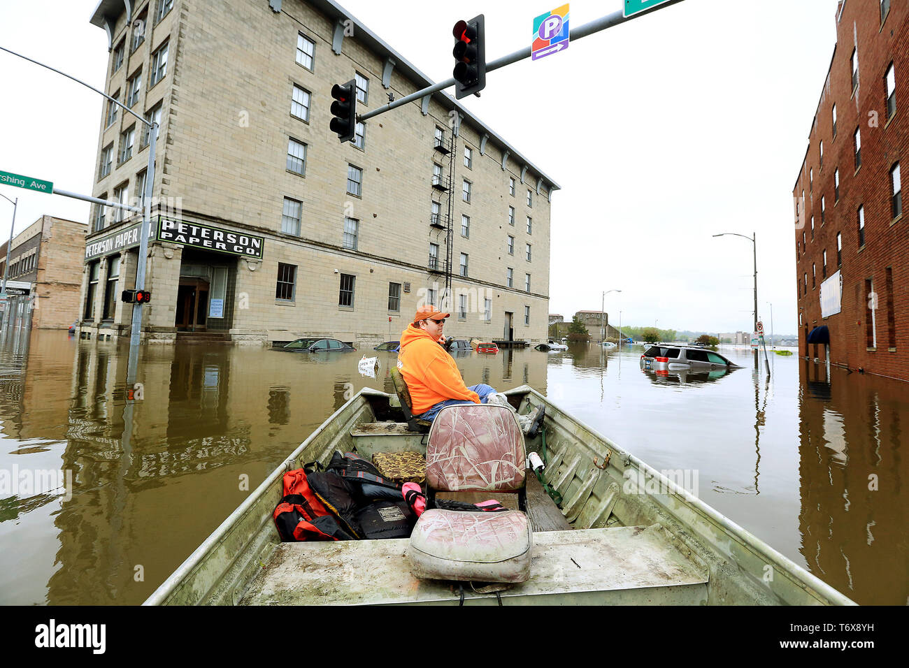 Davenport, Iowa, USA. Il 2 maggio, 2019. Ryan manovre di Lincoln suo jon imbarcazione attraverso l'acqua di allagamento all'intersezione di Pershing Ave e e 2a San giovedì 2 maggio 2019. Lincoln del datore di lavoro di Hahn Ready Mix gli ha consentito di prendere il tempo fuori dal lavoro di volontariato che stava trasportando persone avanti e indietro per i loro appartamenti e le imprese colpite dalle inondazioni nel centro cittadino di Davenport. Credito: Kevin E. Schmidt/Quad-City volte/ZUMA filo/Alamy Live News Foto Stock