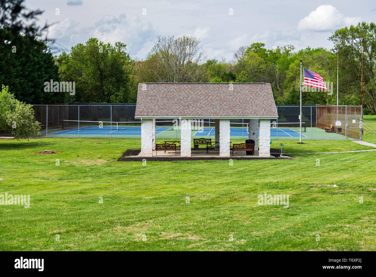 Recintato campo da tennis con un gazebo o shelterhouse. Bandiera americana su un palo, STATI UNITI D'AMERICA. Foto Stock
