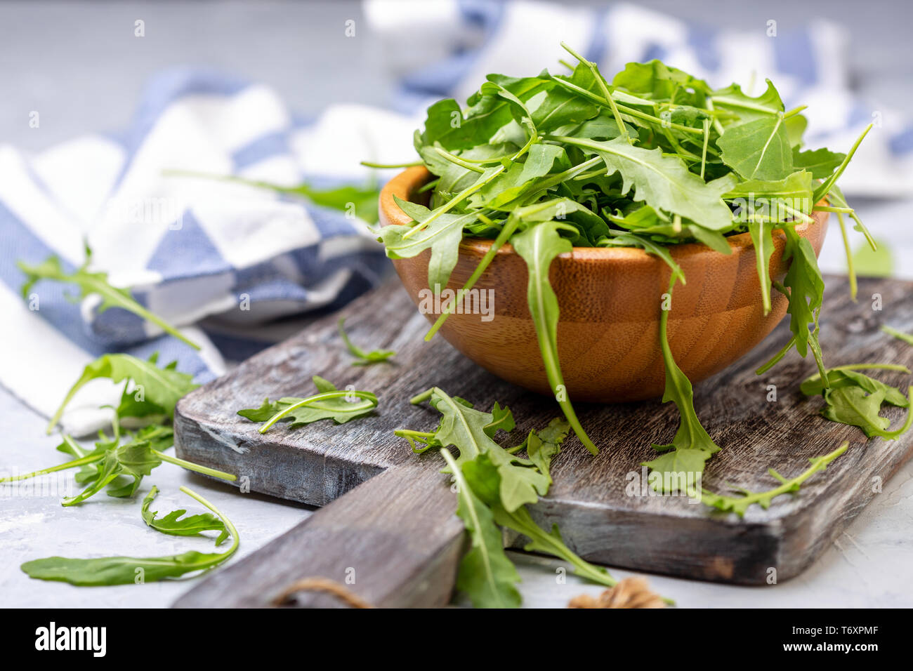 Foglie di rucola per insalata in una ciotola di legno. Foto Stock Foglie di rucola per insalata in una ciotola di legno. Foto Stock
