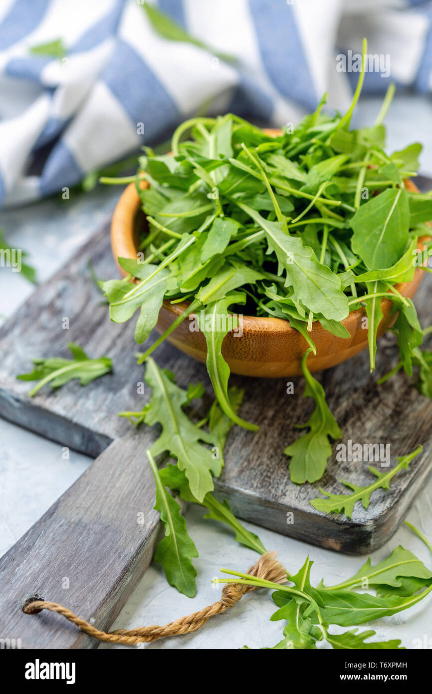 Foglie di rucola in una ciotola di legno. Foto Stock