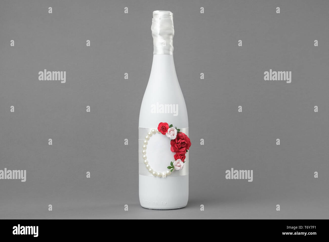 Nozze bottiglia di champagne decorate con rose, perle e nastro. Copia spazio per il testo. Foto Stock
