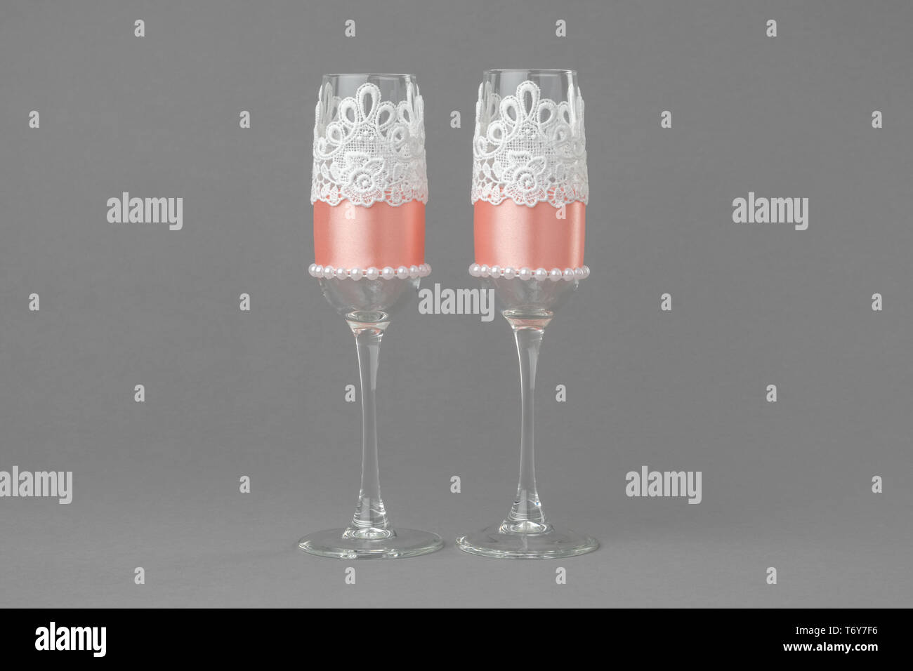Matrimonio di due bicchieri di vino decorate con pizzo, perle e nastro. Foto Stock