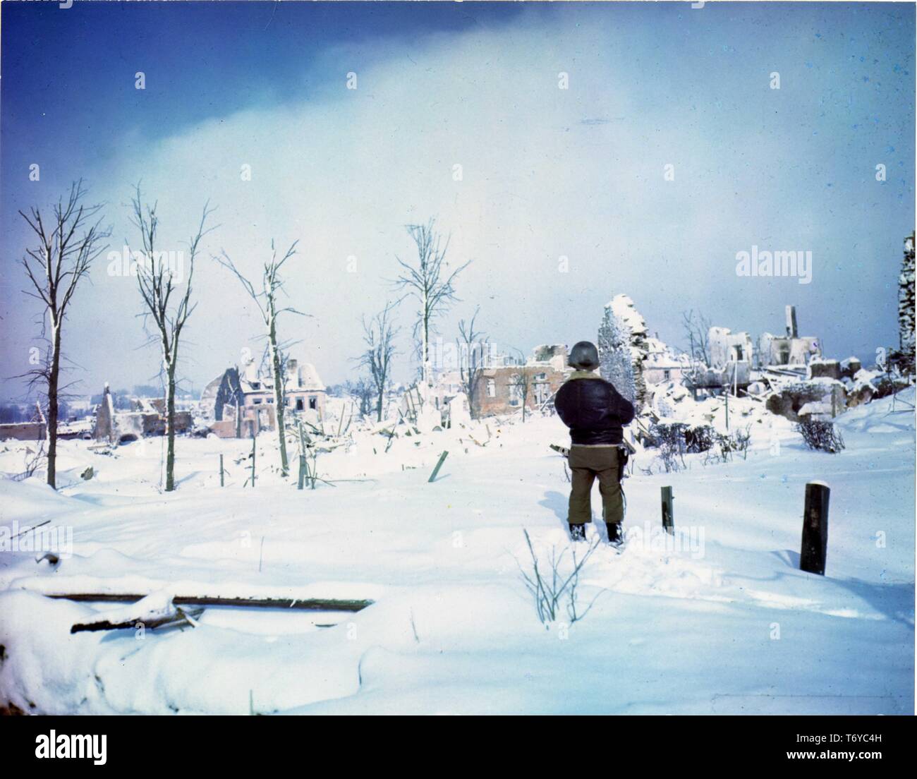 Soldier guarda il relitto in St Vith, Belgio, dopo l'unità della settima divisione corazzata ha preso la città durante la Battaglia di Bulge durante la II Guerra Mondiale, 1945. Immagine cortesia archivi nazionali. () Foto Stock