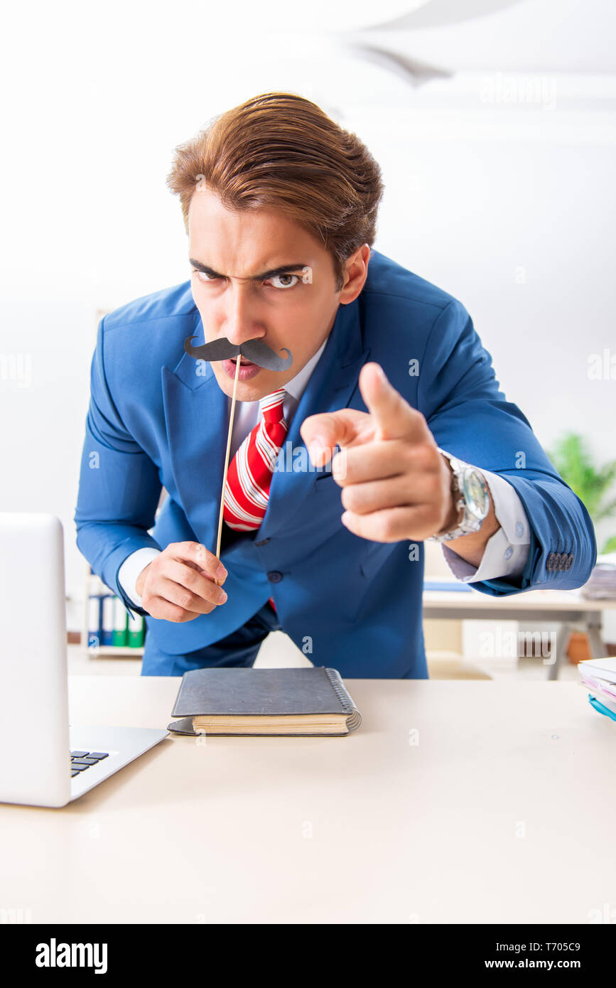 Funny bisinessman con baffi finti in ufficio Foto Stock