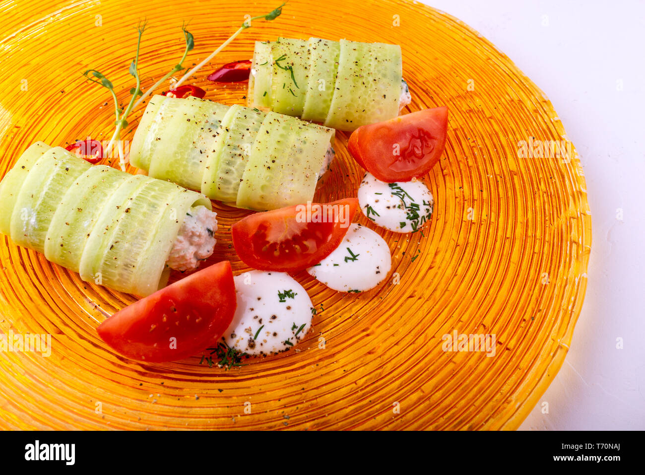 Il cibo italiano su sfondo bianco. Mozzarella, di foglie di basilico fresco, pomodoro, olio d'oliva, panini al formaggio e verdi sulla piastra. Macro Foto Stock