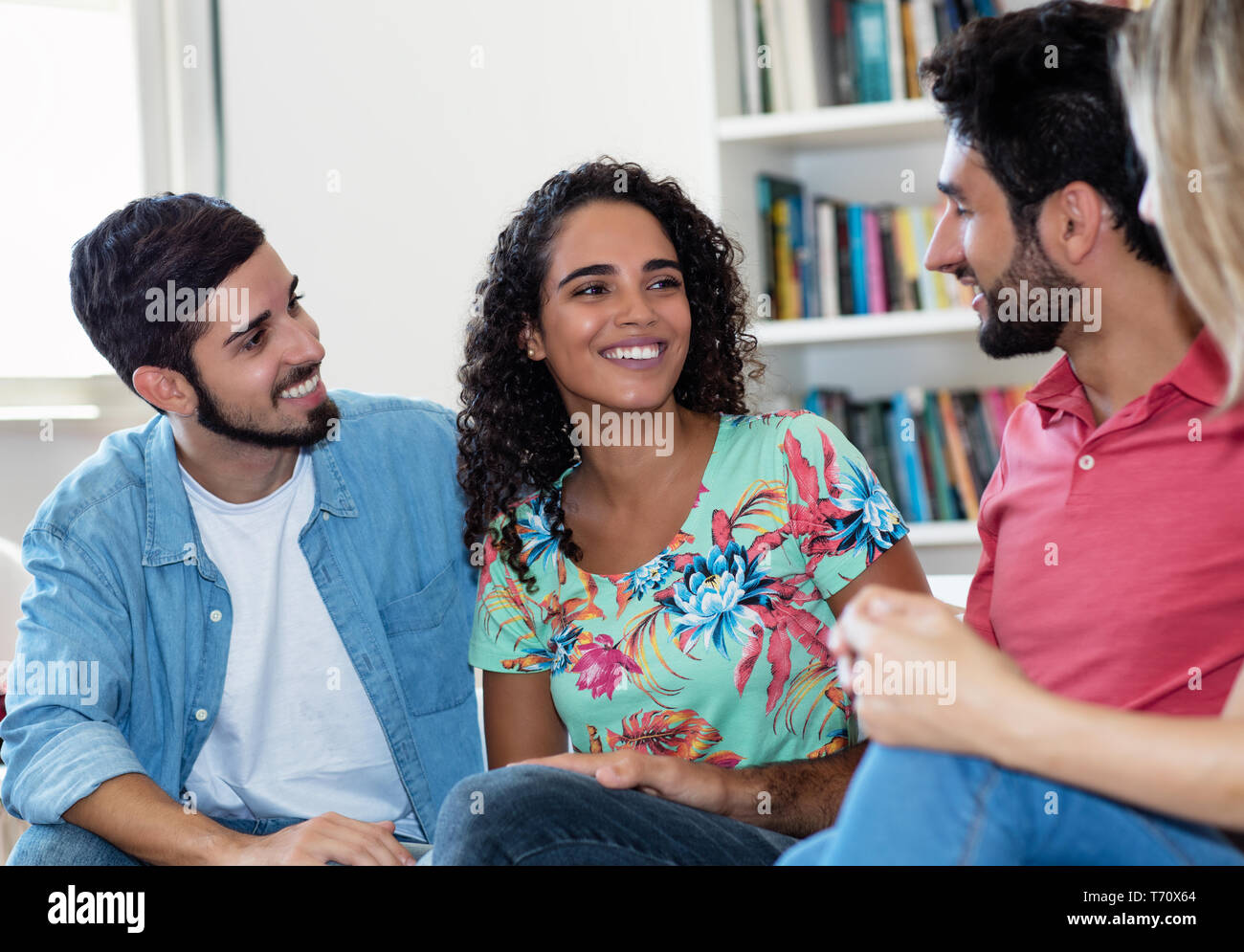 Bella donna latinoamericana a parlare con gli amici in luoghi chiusi a casa Foto Stock
