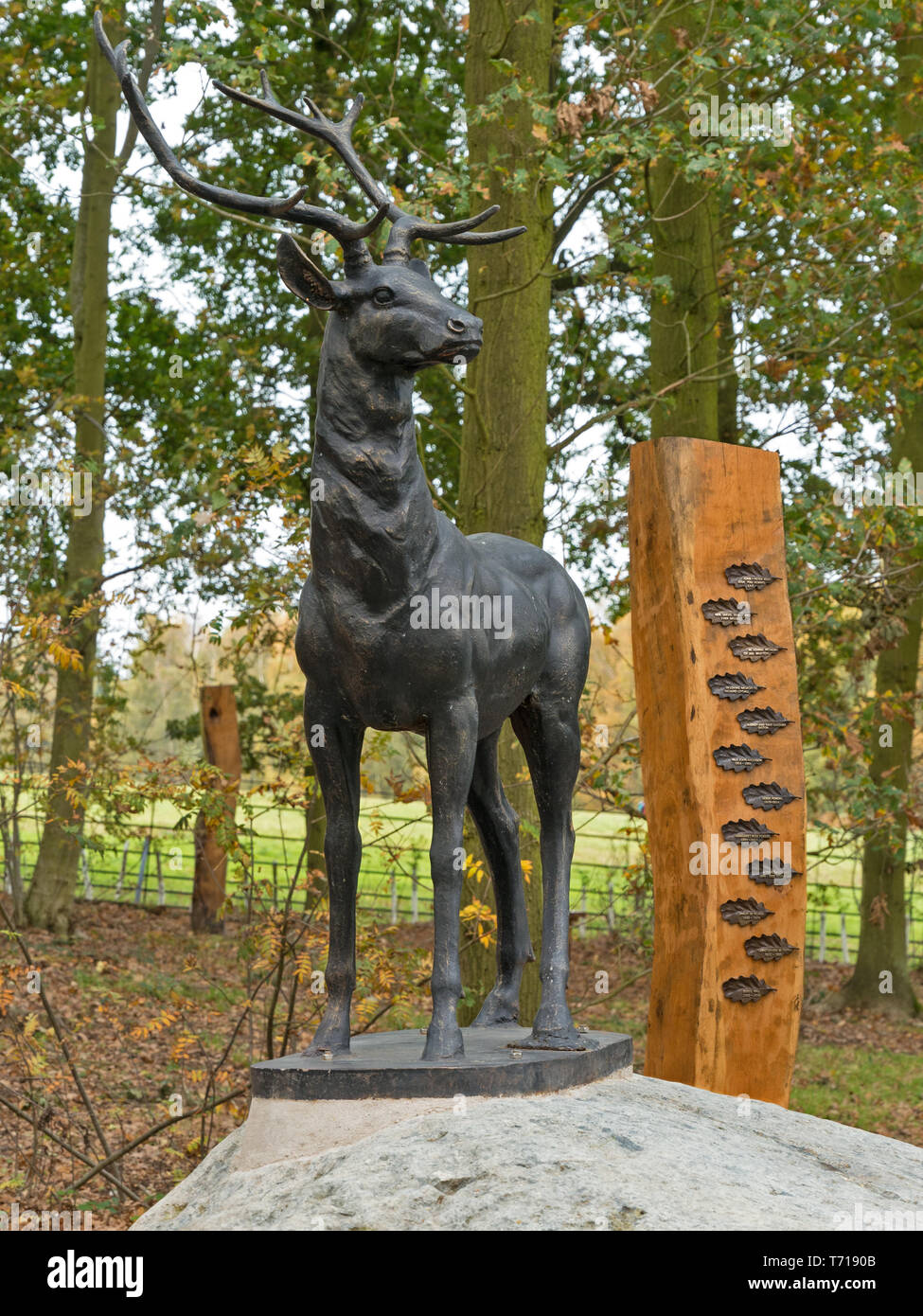 Scultura di cervi rossi feste di addio al celibato e pilastro di quercia con placche di ricordo nella Glenfield Lodge Park Memorial legno, Leicestershire, Inghilterra, Regno Unito. Foto Stock