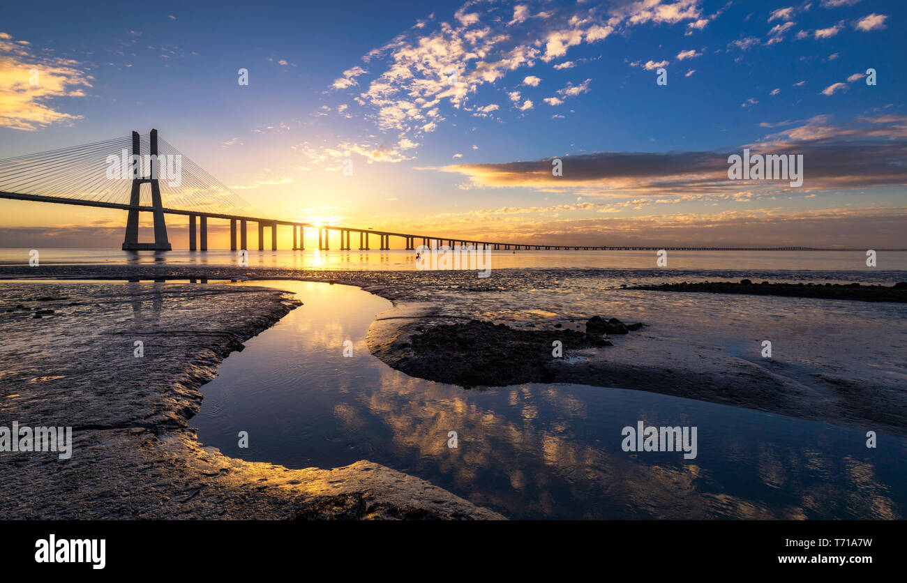 Dal ponte Vasco da Gama a sunrise a Lisbona, Portogallo. Dal ponte Vasco da Gama è un cavo-alloggiato bridge affiancato da viadotti e rangeviews che abbraccia il T Foto Stock