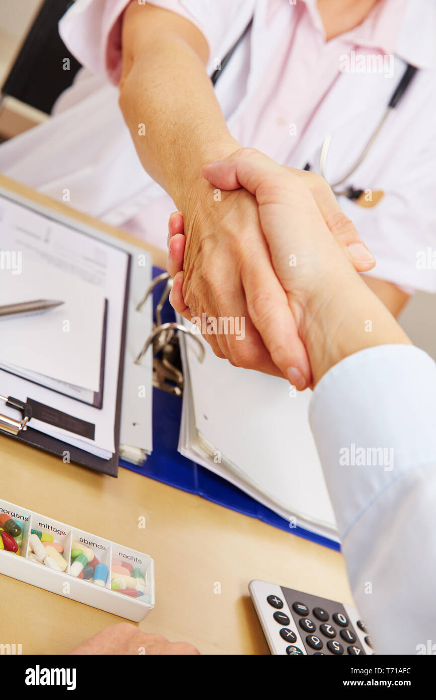 Stretta di mano tra il medico e il paziente in pratica Foto Stock