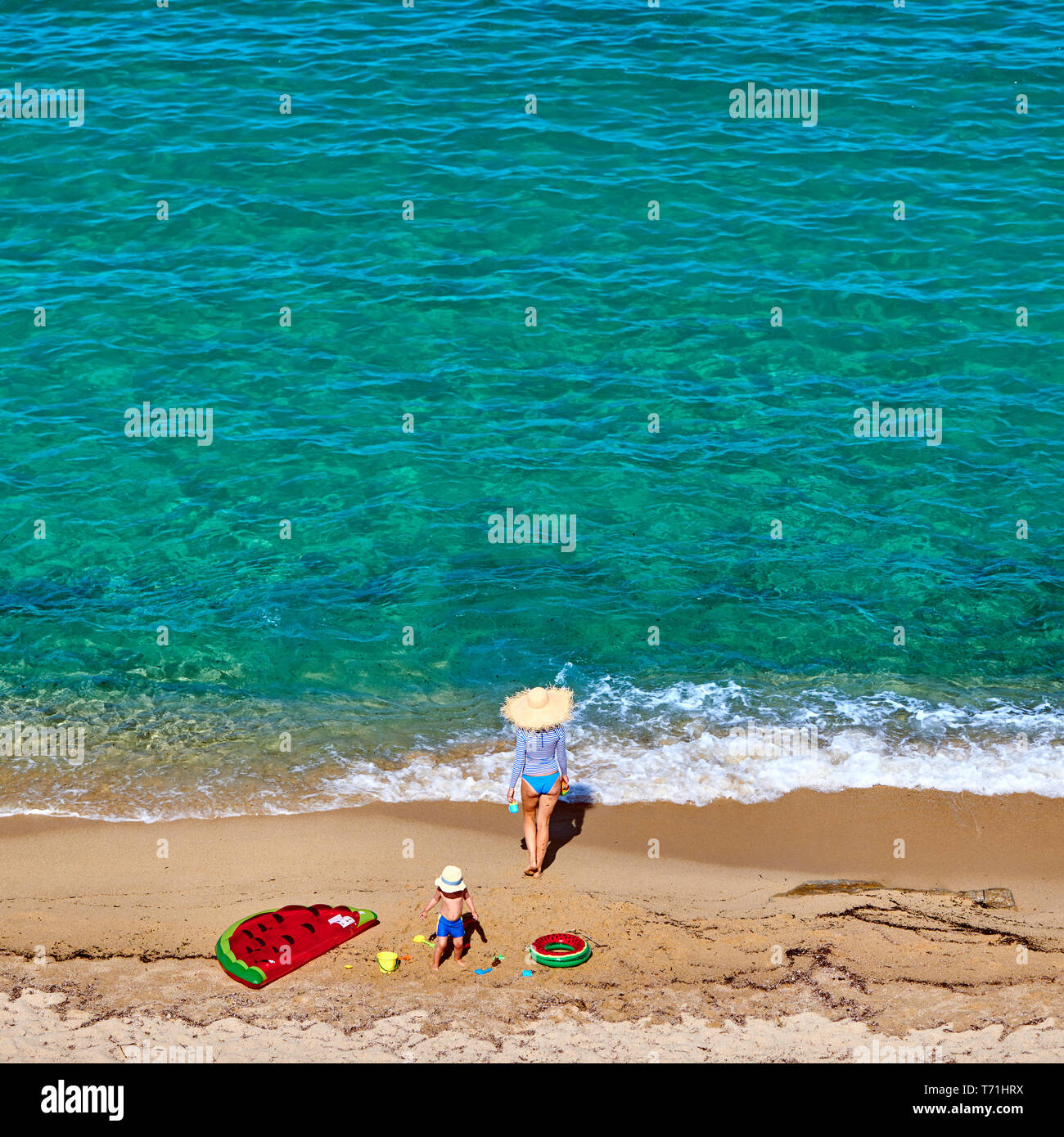 Ragazzo e la sua madre sulla spiaggia con galleggiante gonfiabile Foto Stock