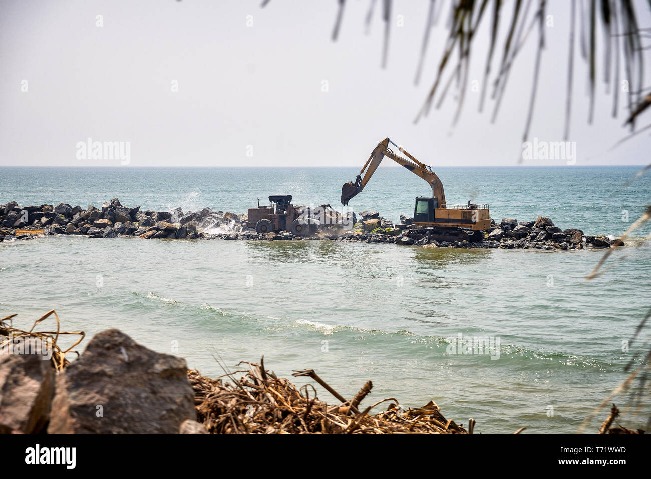 Trattore escavatore e vicino al mare Foto Stock