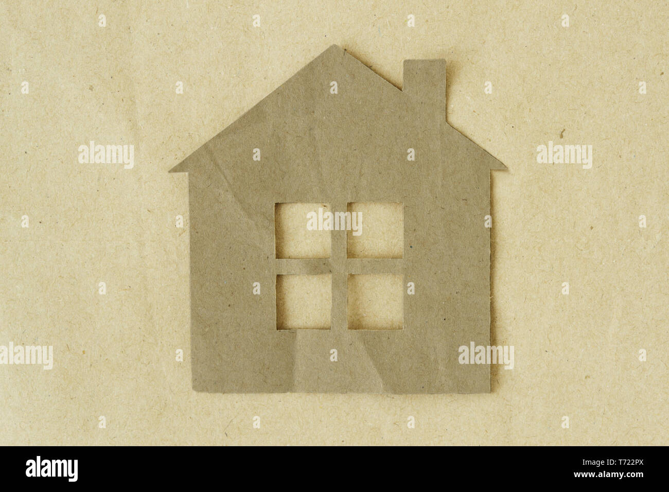 Carta tagliata della casa su carta riciclata in background - Eco-house concept Foto Stock