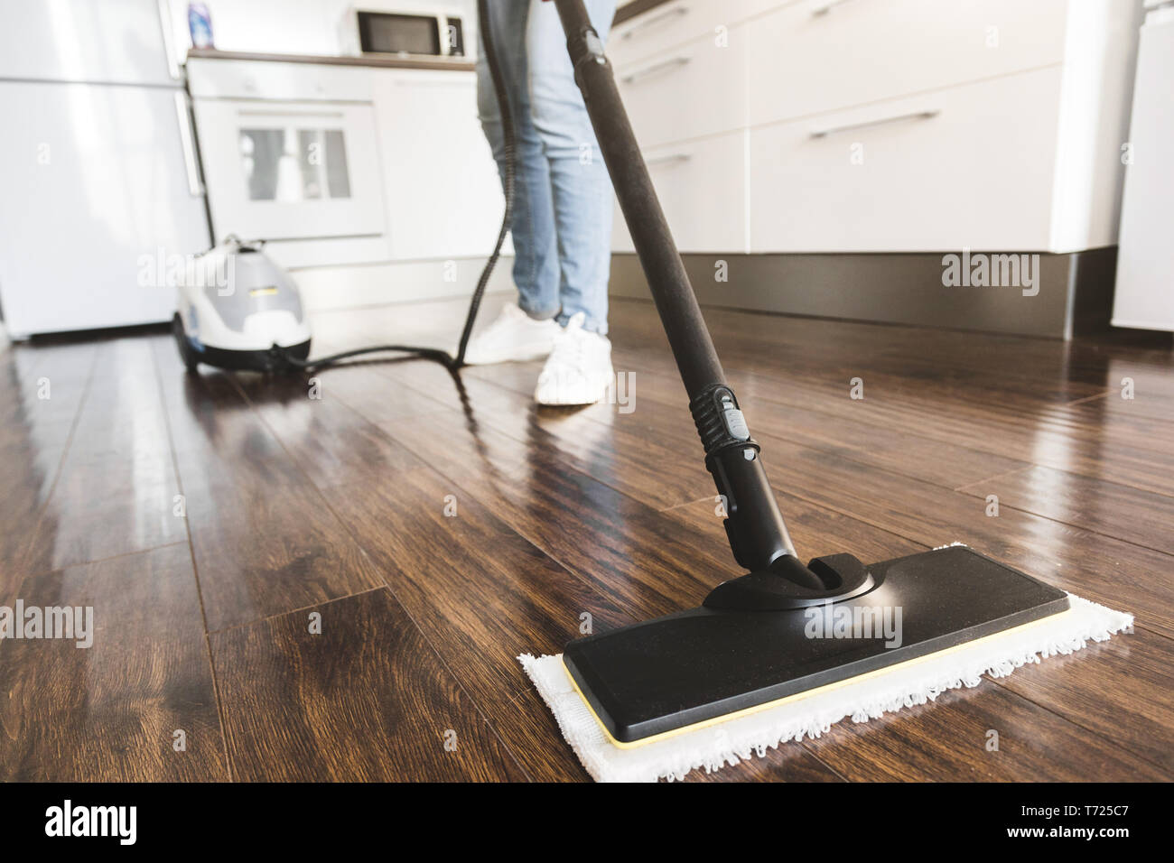 Professional home servizio di pulizia. La donna lava il pavimento con un mop vapore Foto Stock