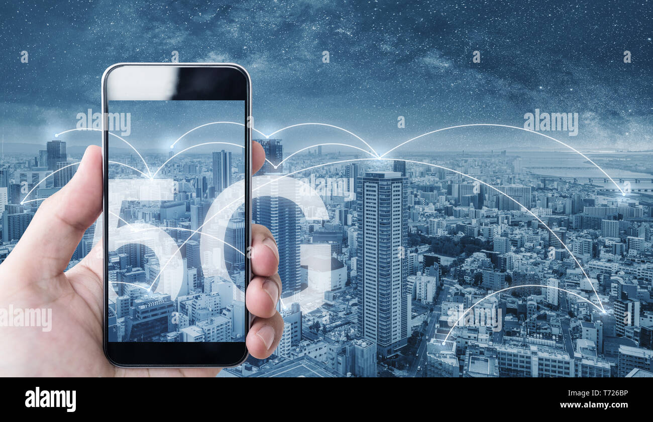 Mano utilizzando mobile smart phone, e la connessione di rete wireless della tecnologia nella città, con 5g internet segno di networking Foto Stock